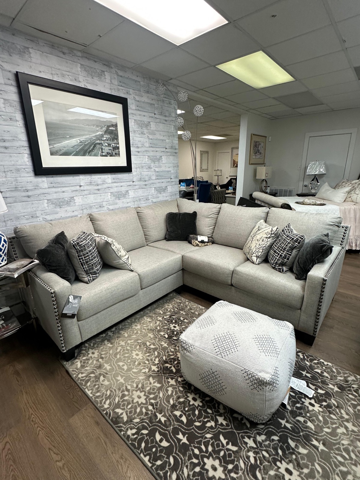 Beige sectional sofa with nailhead trim and decorative pillows
