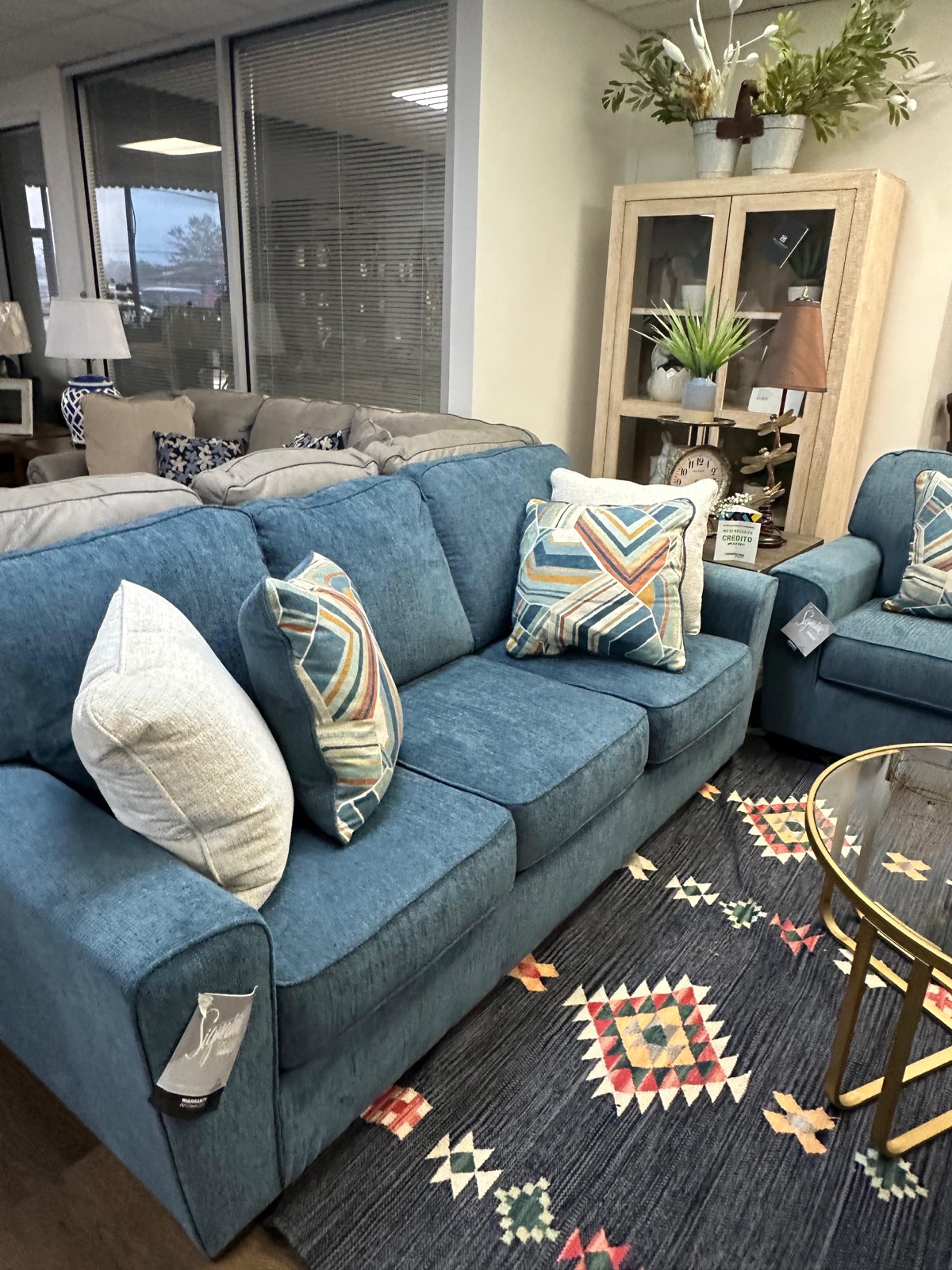 Blue sofa with colorful geometric pillows and bohemian rug