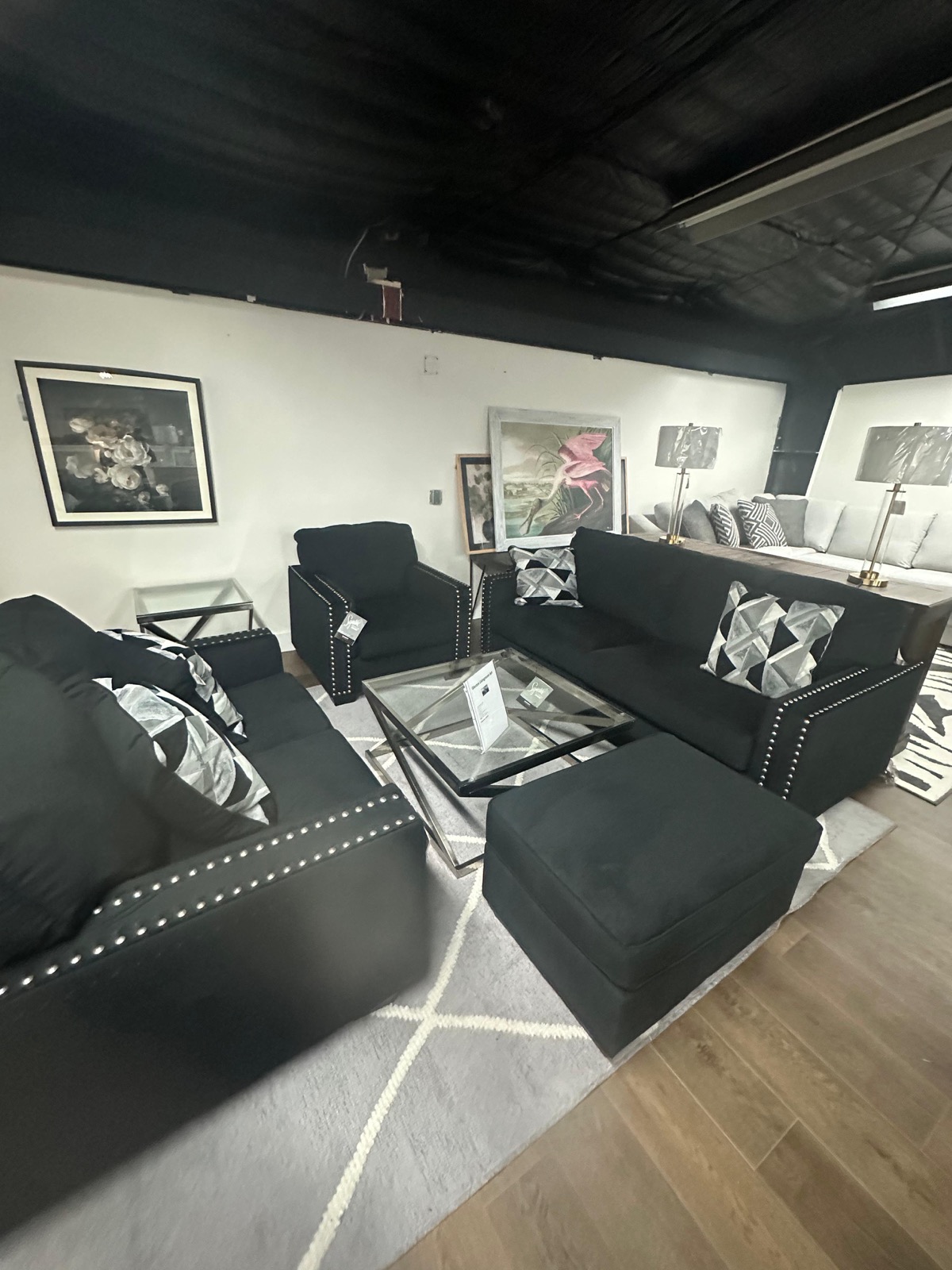Black sofa set with nailhead trim and glass coffee table